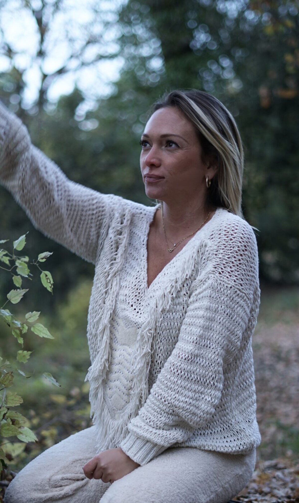 Barbara Tchoroukian en extérieur, assise près d'un arbre au crépuscule.